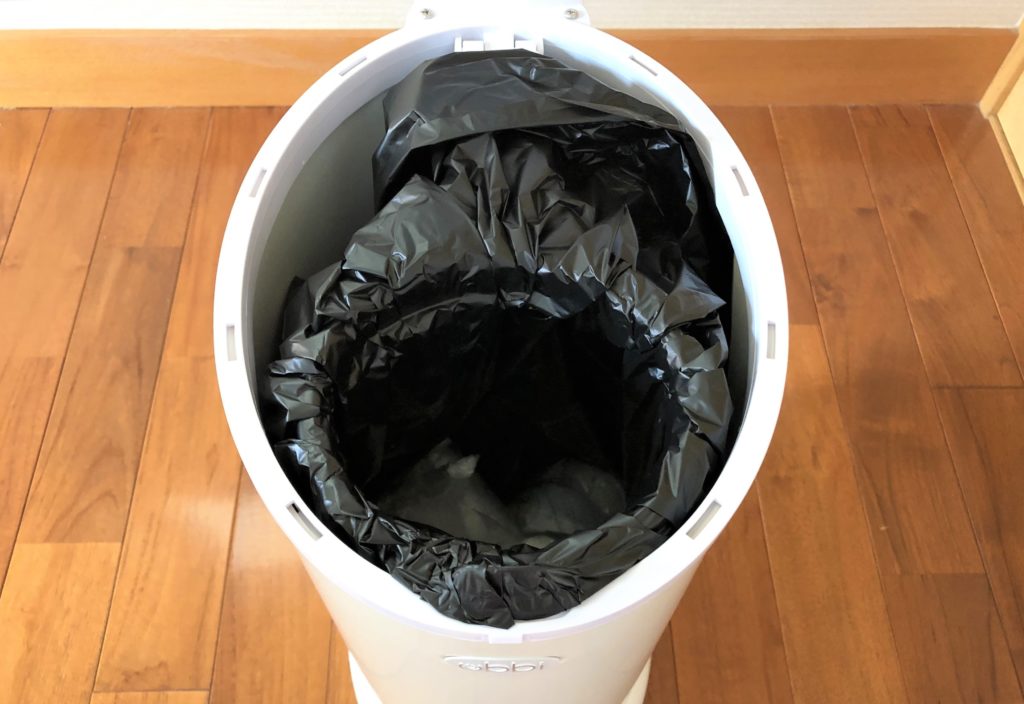 ブログ「モノオス」おむつ用ゴミ箱ubbiのフタを開けて、市販の黒いゴミ袋をはめて撮っている画像